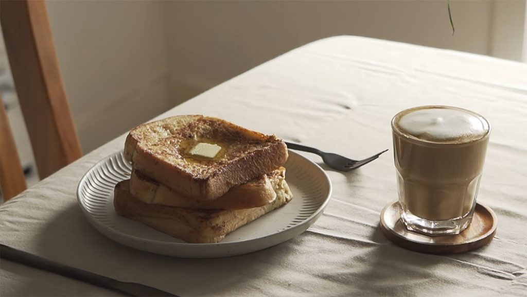 Một bàn ăn sáng với ly cà phê nóng và bánh mì